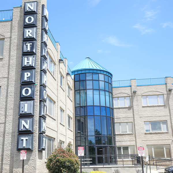 modern northpoint building with blue-tinted glass atrium and cream colored exterior